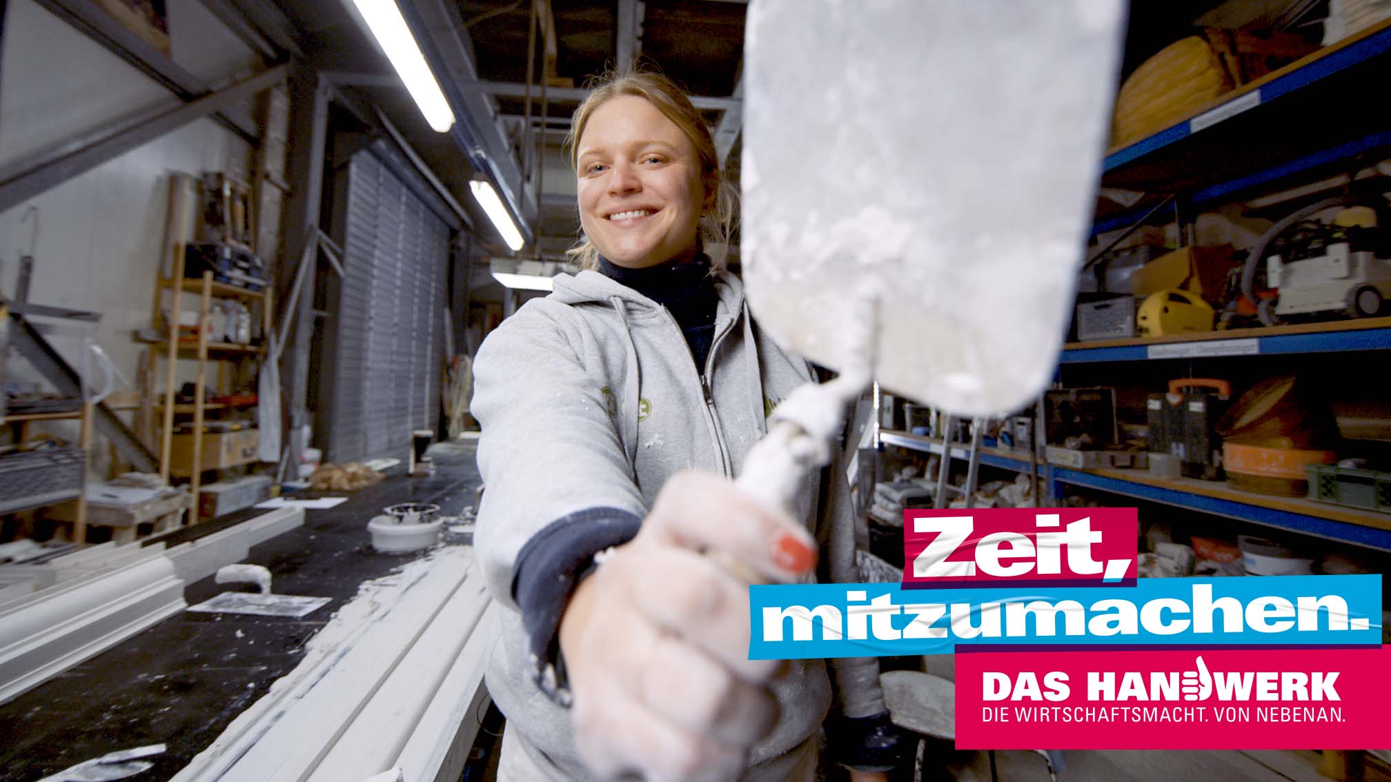 Handwerkerin zeigt Kelle in die Kamera