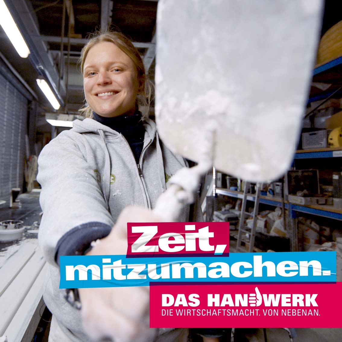 Handwerkerin zeigt Kelle in die Kamera