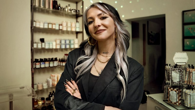 Eine stolze Friseurin blickt in die Kamera